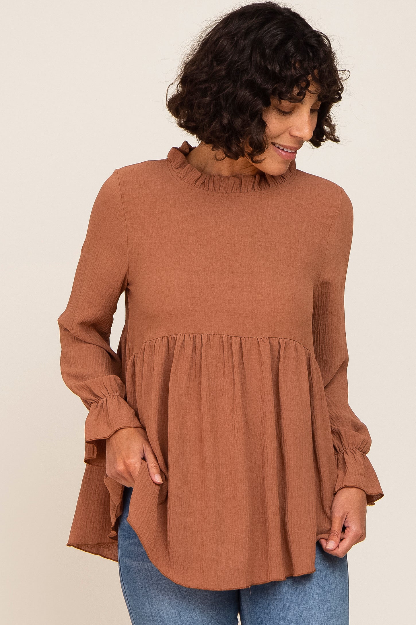 This Peplum Bell Sleeve Blouse with a ruffled hem takes Beige